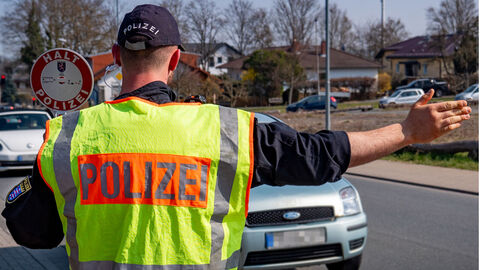 Symbolbild einer Kontrollstelle - Polizist gibt Anhaltzeichen