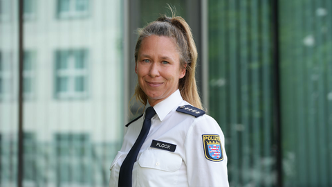 Michaela Plock in weißer Uniform vor einem Gebäude