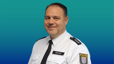 Polizeibeamter mit kurzen dunklen Haaren im weißen Diensthemd mit Krawatte