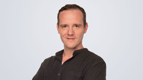 Björn Büchler vor grauem Hintergrund