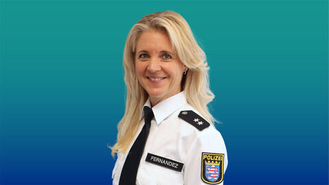 Polizeibeamtin mit langen blonden Haaren im weißen Diensthemd mit Krawatte