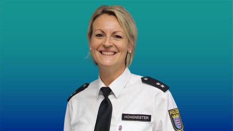 Polizeibeamtin mit blonden mittellangen Haaren im weißen Diensthemd mit Krawatte