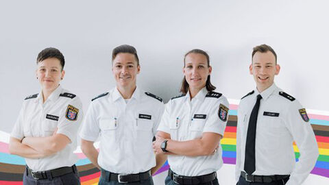 Ansprechpersonen LSBTI:Q der Polizei Frankfurt in Uniform mit regenbogenfarben im Hintergrund