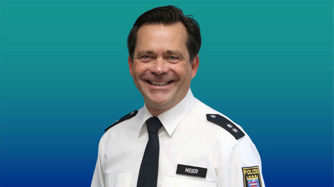 Polizeibeamter mit kurzen schwarzen Haaren in im weißen Diensthemd mit Krawatte