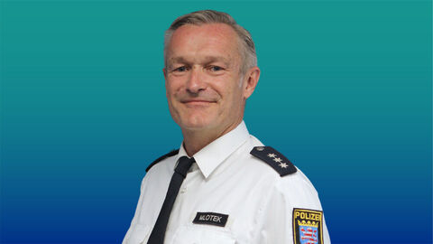 Polizeibeamter mit kurzen grauen Haaren im weißen Diensthemd mit Krawatte