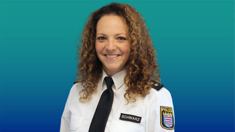 Polizeibeamtin mit langen dunklen Haaren im weißen Diensthemd mit Krawatte