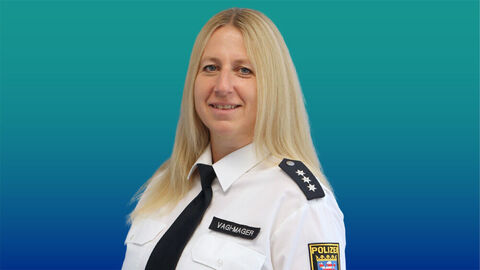 Polizeibeamtin mit langen blonden Haaren im weißen Diensthemd mit Krawatte