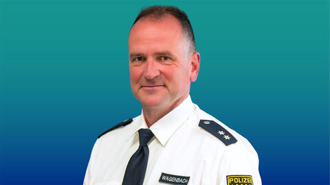 Polizeibeamter mit kurzen dunklen Haaren im weißen Diensthemd mit Krawatte