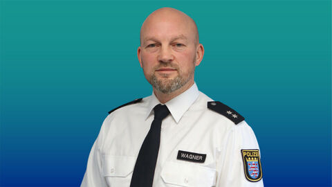 Polizeibeamter mit sehr kurzen Haaren und Bart im weißen Diensthemd mit Krawatte