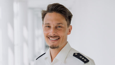 Heinrich Falk in weißem Uniformhemd und hellem Hintergrund