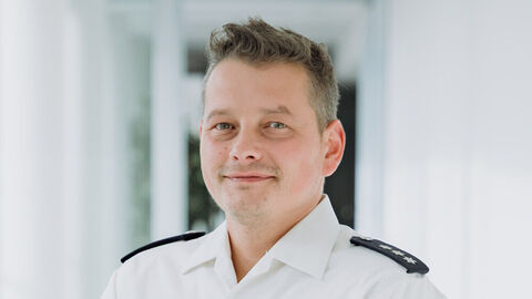 Martin Leskov in weißem Uniformhemd und hellem Hintergrund