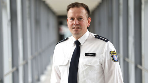 Polizist in weißem Uniformhemd in einem langen Glasdurchgang