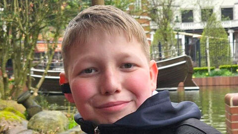 Foto des vermissten Leon S. vor unscharfen Hintergrund im Garten sitzend