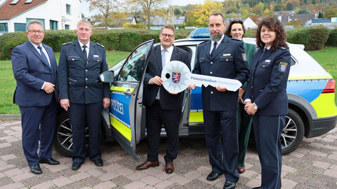 Neue Leitung der Polizeistation Schwalmstadt; Gruppenfoto zeigt mehrere nebeneinander stehende Personen vor einem Streifenwagen, in der Mitte überreicht PP Bärtl einen symbolischen Schlüssel mit Polizeistern und Schriftzug Polizeipräsidium Nordhessen (ca. 80 cm groß)  an Matthias Ebert