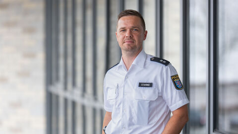 Schutzmann vor Ort Manuel Starke vor Glaswand 