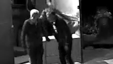 Unbekannte Täter, die einen Rollcontainer aus einer Halle schieben