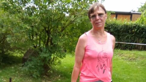 Die Vermisste Frau in Ganzkörperaufnahme. Sie ist 170cm groß, schlank und hat kurze, braune Haare. Auf dem Bild führt sie einen Hund bei sich