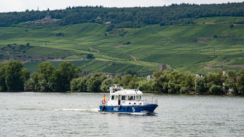 as schwere Streifenboot der Wasserschutzpolizei Rüdesheim auf dem Rhein im Hintergrund Weinberge und das Niederwalddenkmal