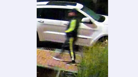 01 Tatverdächtige Person im Trainingsanzug mit neongelben Applikationen auf Gehweg