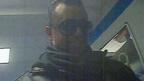 Unbekannter Täter steht an einem Geldautomaten - Frontansicht