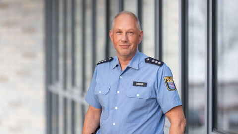 Portraitbild des unifomrierten "Schutzmann vor Ort" Gunter Weber, vor Glasfromt