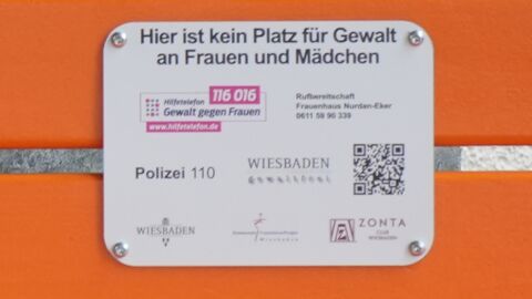 Hinweisschild auf der orangen Bank