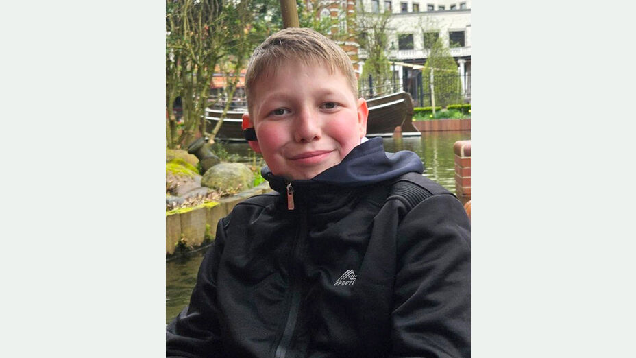 Foto des vermissten Leon S. vor unscharfen Hintergrund im Garten sitzend